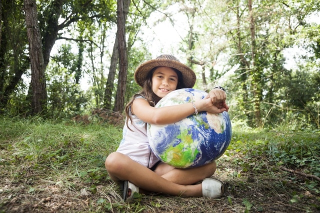 Little girl embracing world globe